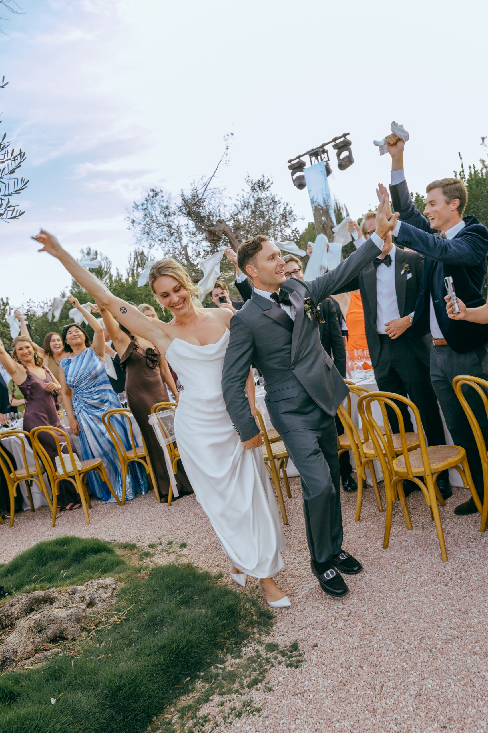 Gaia and Luke exchanging vows in front of a dusty pink draped ceremony backdrop at Ca Na Xica in Ibiza.